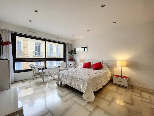 une chambre avec un lit, une table et des chaises dans l'établissement Gray d Albion THI235, à Cannes