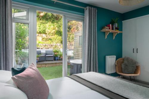 a bedroom with a bed and a large window at Number 4 - Stylish 1 bedroom house in Truro, Cornwall in Truro