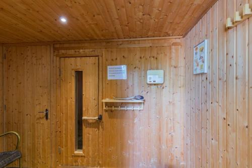 a wooden wall with a door in a room at 8 pers vakantiehuis met natuur- sauna en bubbelbad in Diessen