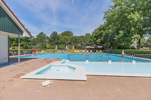 a large swimming pool with a pool at 8 pers vakantiehuis met natuur- sauna en bubbelbad in Diessen