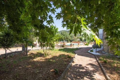 a path through a park with trees in the foreground at Yeşilkaya Hotel in Kayakoy