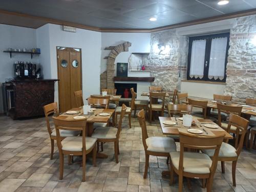 a restaurant with wooden tables and chairs and a fireplace at Hotel B&B Pescofalcone in Caramanico Terme