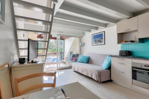 un petit salon avec un canapé et une cuisine dans l'établissement À 100m de la plage, Carnac, duplex vue mer pour 3, à Carnac