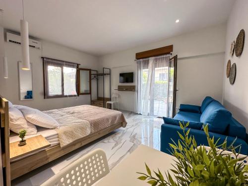 1 dormitorio con 1 cama y 1 sofá azul en MIRA LUXURY APARTMENTS en Paralia Dionysiou