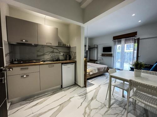 cocina y sala de estar con mesa y cama en MIRA LUXURY APARTMENTS en Paralia Dionysiou
