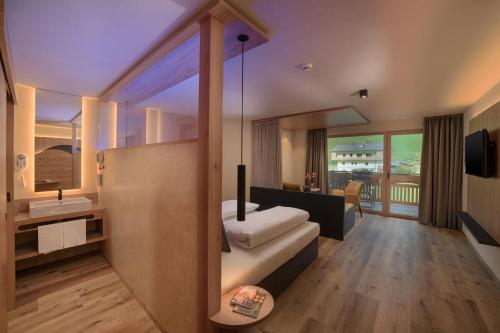 ein Hotelzimmer mit einem Bett und einem Bad in der Unterkunft Martinshof berg herz hotel in St. Johann im Ahrntal