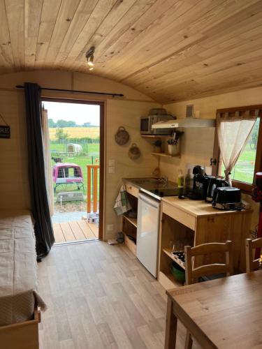 małą kuchnię ze stołem i blatem w obiekcie La Ferme de Roulotte de Sandrine w mieście Carentoir