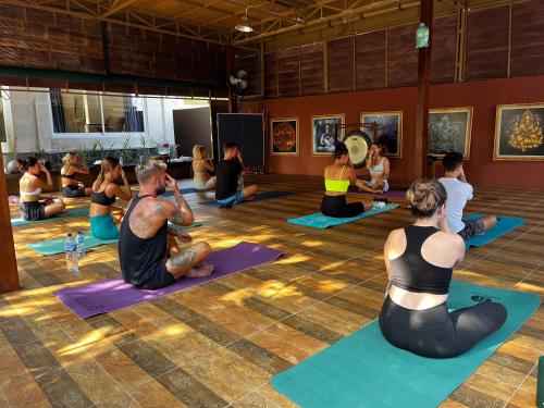 a group of people sitting in a yoga class at Villa Neshama in Canggu