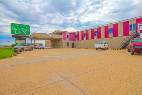 un grande edificio con auto parcheggiate in un parcheggio di HomeTown Inn By OYO - Liberal, KS a Liberal