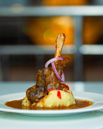 a piece of food on a plate with meat and sauce at Gold Crest Hotel in Mwanza