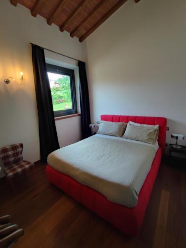 a bedroom with a red bed with a window at Villa Giulia Fashion B&B in Strada