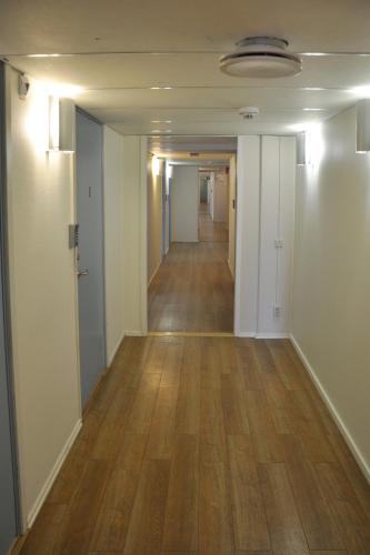 an empty hallway in an office building with wood floors at Brandbergens Vandrarhem in Haninge
