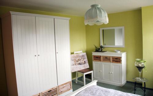 a bedroom with a white cabinet and a mirror at Ferienwohnung Nagel 