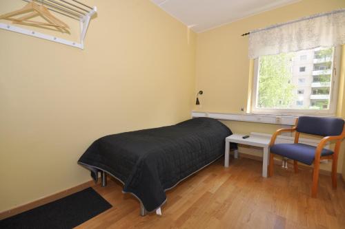 a bedroom with a bed and a desk and a window at Brandbergens Vandrarhem in Haninge