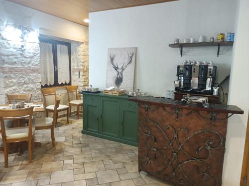 a kitchen with green cabinets and a table and chairs at Hotel B&B Pescofalcone in Caramanico Terme