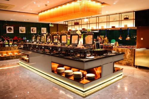 a restaurant with a counter with food on it at Zhuo Ruiyunrui Hotel in Dongliucun