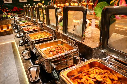 a buffet line with many trays of food at Zhuo Ruiyunrui Hotel in Dongliucun