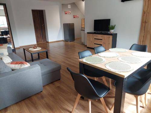 a living room with a table and a couch at Noclegi i sauna w starym domu in Pławnica