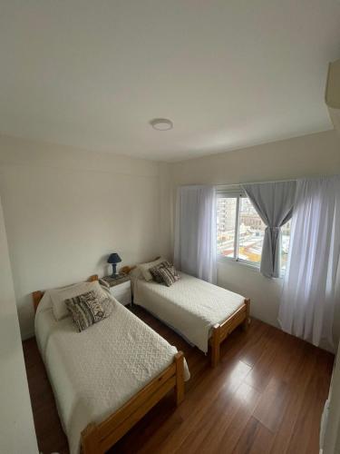 a bedroom with two beds and a window at Departamento en Plaza Mitre, inmejorable! in San Nicolás de los Arroyos