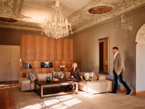 a man walking through a living room with a woman at Hotel Hofwirt in Seckau