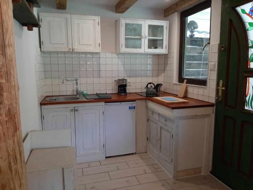 a small kitchen with white cabinets and a sink at Domki w Lipowej Dolinie in Huta Górna