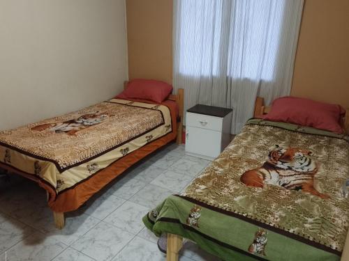 a bedroom with two beds and a window at Cabañas Comarca de la Quebrada in Potrerillos