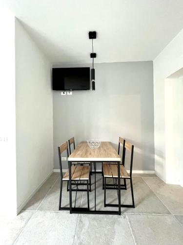 a dining room table with chairs and a tv on a wall at Casa Teresa in Riva del Garda
