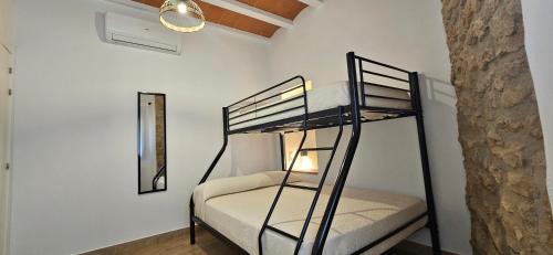a bunk bed in a room with a mirror at Casa Les Carolines in Camarles