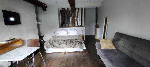 a bedroom with a bed and a couch at Clos Masure hôtel de campagne in Belmesnil