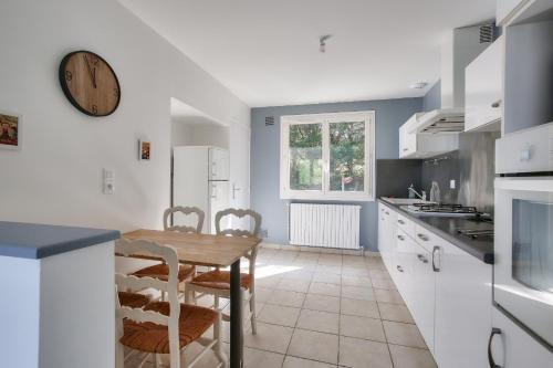 une cuisine avec une table et une horloge au mur dans l'établissement Erquy- Maison familiale pour 8 adultes et 2 enfants, à Erquy