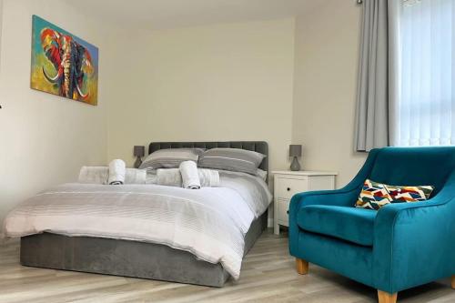 a bedroom with a bed and a blue chair at Royal Haven in Hillsborough