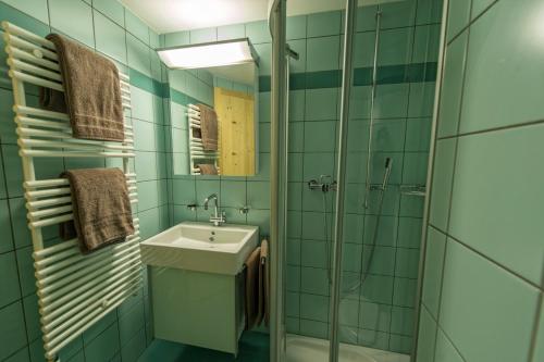 a green bathroom with a sink and a shower at Neiva in Arosa