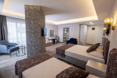 a hotel room with two beds and a living room at Avion Suite Hotel in Antalya