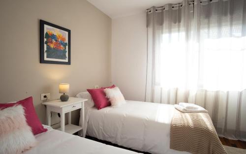 a bedroom with two beds and a window at Preciosa casa cerca de la playa de Samil in Vigo