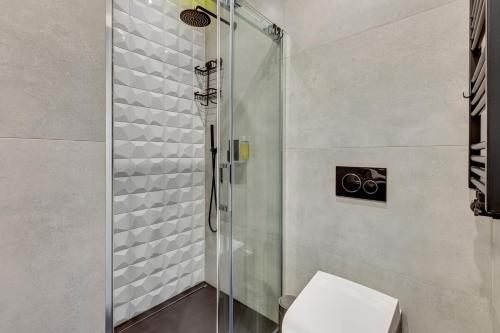 a bathroom with a glass shower with a toilet at GRANO APARTMENTS Gdańsk Old Town SPA & Wellness - GRANO APARTMENTS Gdańsk Residence SPA & Wellness in Gdańsk