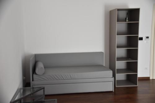 a gray couch in a room with a book shelf at Le Dame Manfrede in Faenza