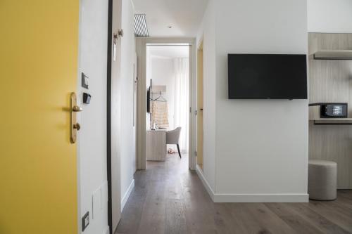 a hallway with a door leading into a room with a television at Hotel Villa Sorriso in Lido di Jesolo