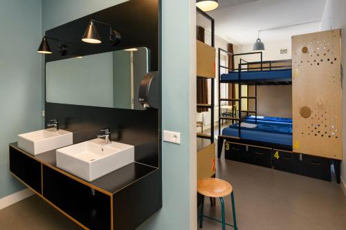 a bathroom with two sinks and a bunk bed at Stayokay Hostel Utrecht Centrum in Utrecht