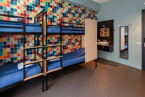 a room with bunk beds with a colorful wall at Stayokay Hostel Utrecht Centrum in Utrecht