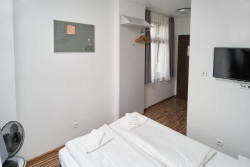 um quarto com um sofá branco e uma televisão de ecrã plano em Akira Bed & Breakfast em Breslávia