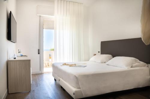 a bedroom with a bed with a cat laying on it at Hotel Villa Sorriso in Lido di Jesolo