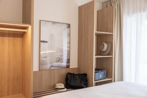 1 dormitorio con 1 cama y una foto de una tabla de surf en Residence Ibaia, en Hendaya