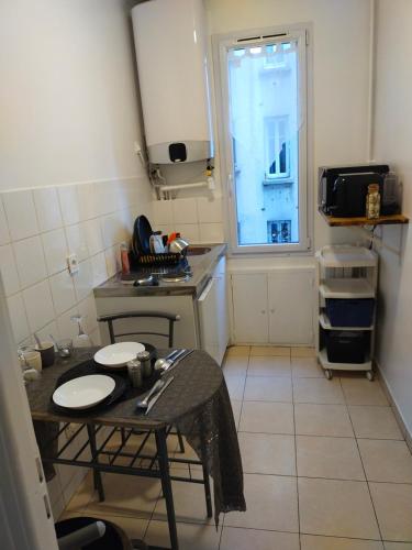 une petite cuisine avec une table et une fenêtre dans l'établissement Josef appartment, à Paris