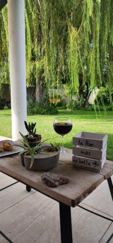 Una mesa de madera con una copa de vino encima. en Alquiler por día, en La Rioja