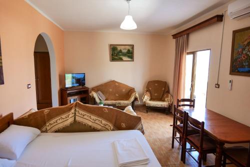 een slaapkamer met een bed en een tafel en stoelen bij Vila Suljo in Ksamil