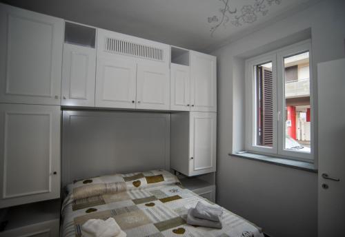 una camera da letto con letto, armadi bianchi e finestra di Corte Paradiso a Torino