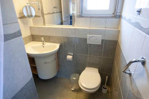 a small bathroom with a toilet and a sink at Randbøldal Camping & Cabins in Randbøl