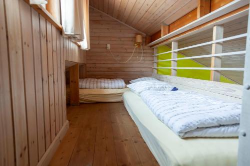 a room with a large bed in a wooden room at Randbøldal Camping & Cabins in Randbøl