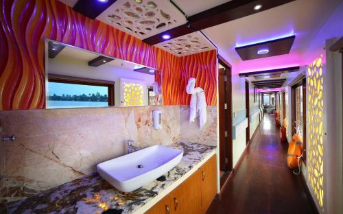 a bathroom with a sink and a large mirror at Angel Blue Houseboat Alapuzha in Alleppey