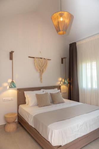 a bedroom with a large bed with white sheets at CeraMio Suites in Limenas